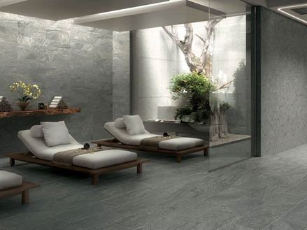 Area benessere con gres porcellanato grigio e due lettini