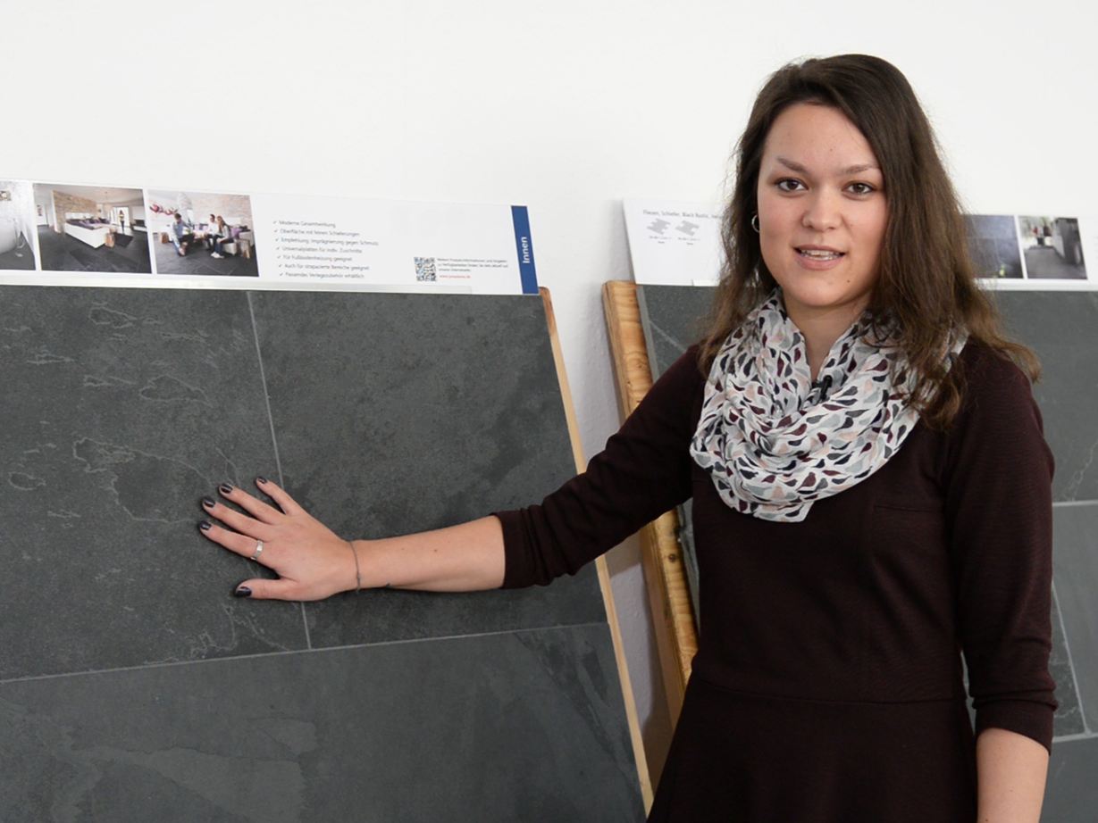 Un dipendente si trova di fronte a pannelli di ardesia campione