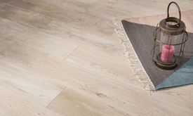 Piastrelle effetto legno Urban White nei toni del beige chiaro con tappeto e lanterna decorativa