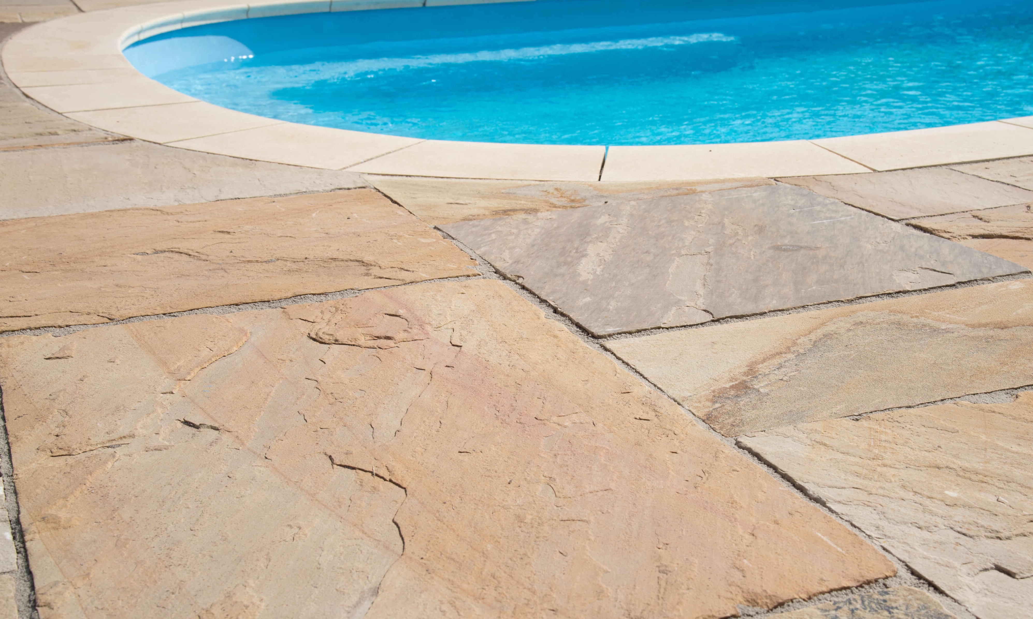 Lastre di arenaria posate a bordo piscina