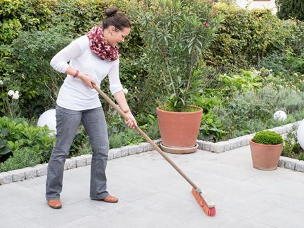 Donna pulisce la terrazza grigia di Granit Mundo