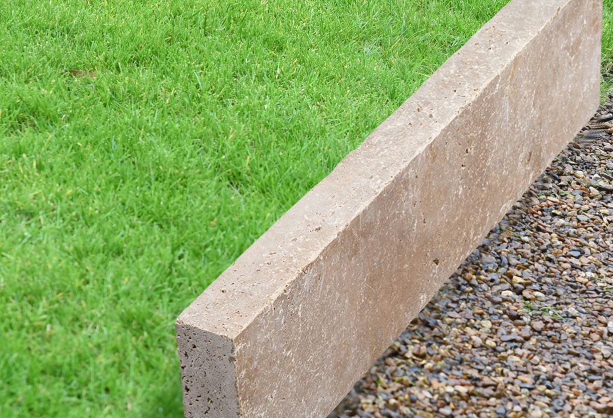 Cordolo per prato in travertino Noce con prato e ghiaia_cutout_banner