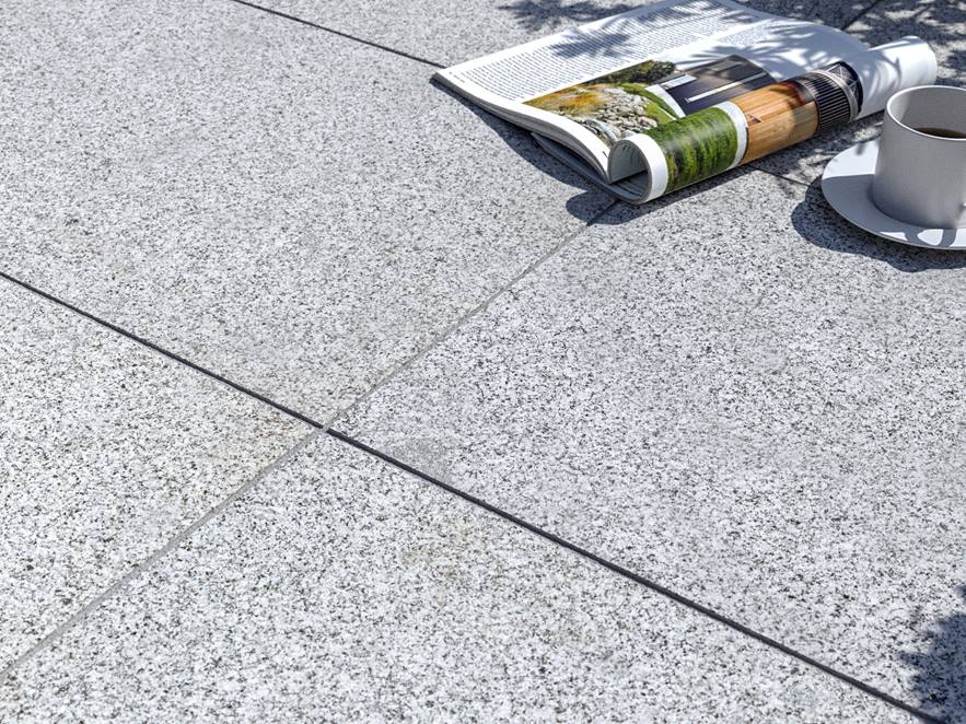 Lastra per patio in granito Silver Classico con rivista e tazza da caffè