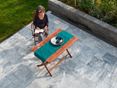 Rilassatevi con stile sulla terrazza di Afyon Grey! Donna seduta a un tavolo di legno su una terrazza con piani di marmo
