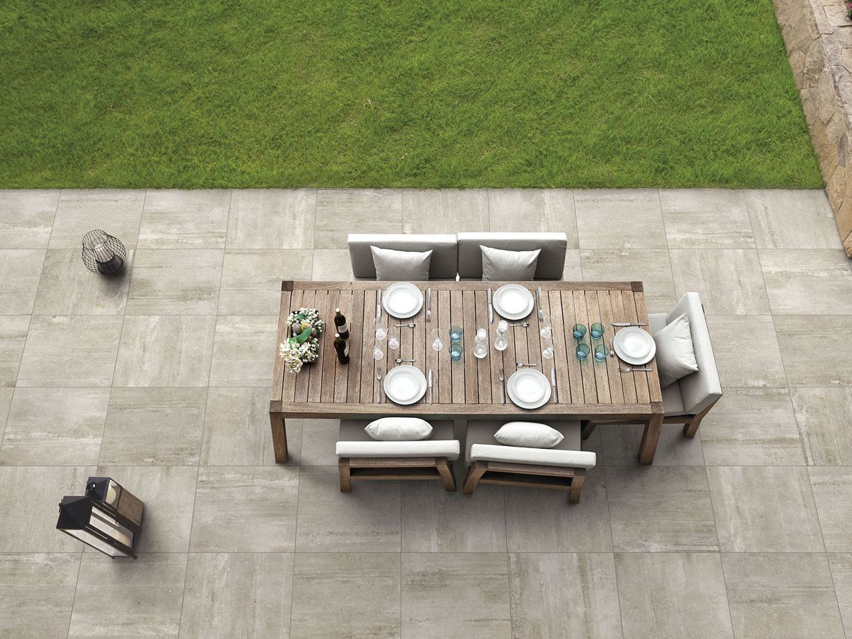 Un moderno paradiso all'aperto: Sabbia di cemento Pannelli beige effetto cemento Sabbia di cemento con terrazza, tavolo e sedie