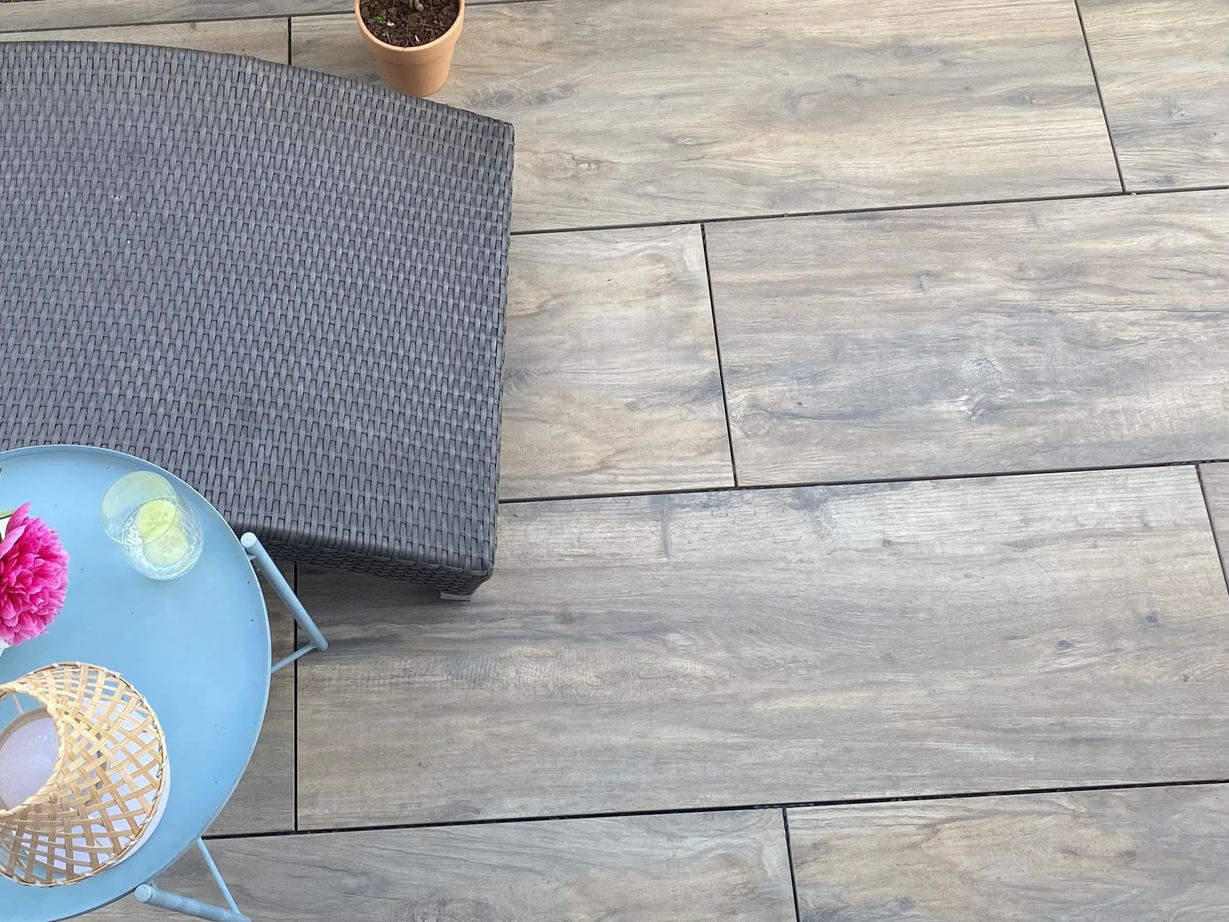 Piastrelle per patio in gres porcellanato effetto legno Canada Lodge con lettino e tavolo