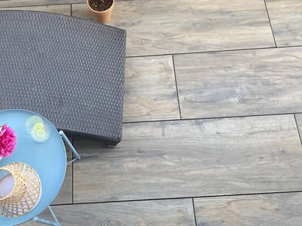 Piastrelle per patio in gres porcellanato effetto legno Canada Lodge con lettino e tavolo