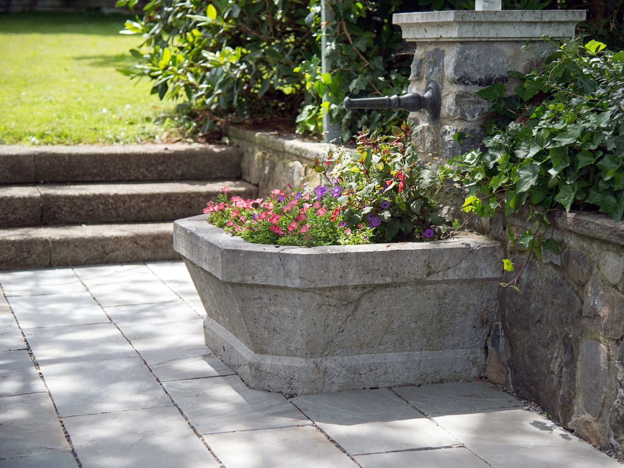 Pietra arenaria per un giardino naturale Lastra di arenaria grigia Kandla Grey Fontana con fiori