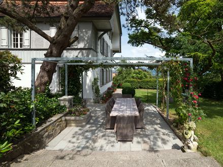 Terrazza con lastre di pietra naturale di arenaria grigia in un giardino naturale
