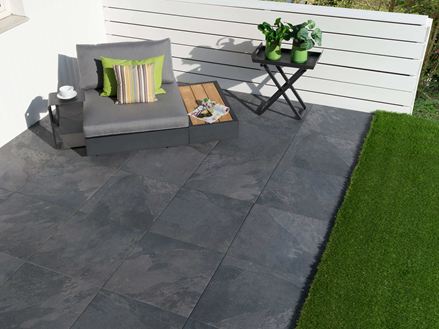 Terrazza con lastre Alpine Black e divano lounge