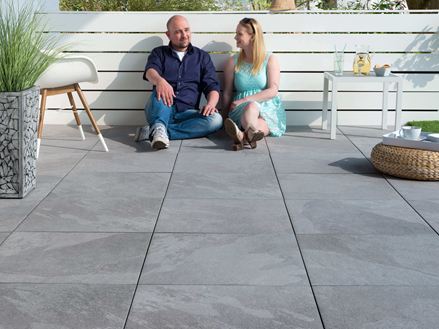 Persone sedute su una terrazza con lastre in ardesia Alpine Grey chiaro