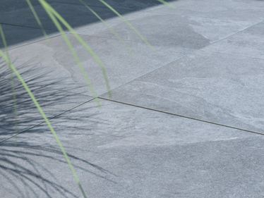 La pianta fa ombra alla terrazza con lastre effetto ardesia Alpine Grey