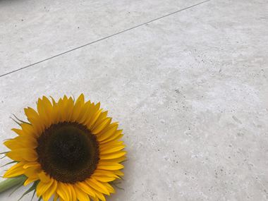 Sensazione di estate sulla terrazza con il travertino di Siena Piastrelle effetto travertino di Siena con girasole