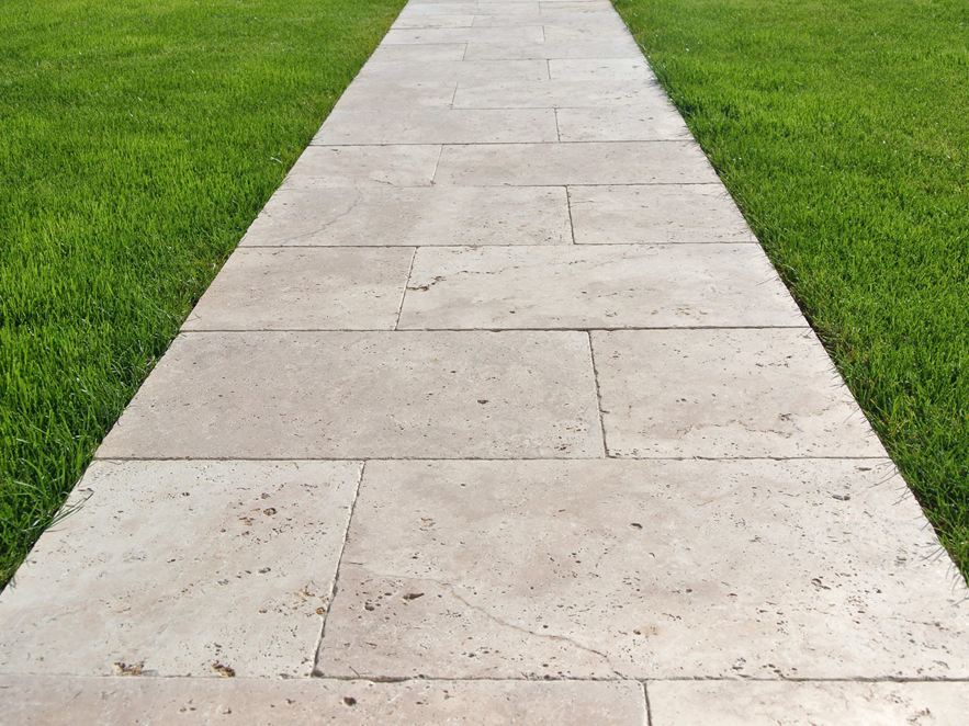 Passerella in lastre di travertino sul prato