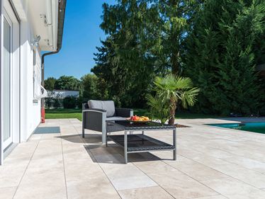 Mobili in rattan su una terrazza chic in travertino