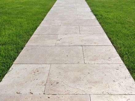 Passerella in lastre di travertino sul prato