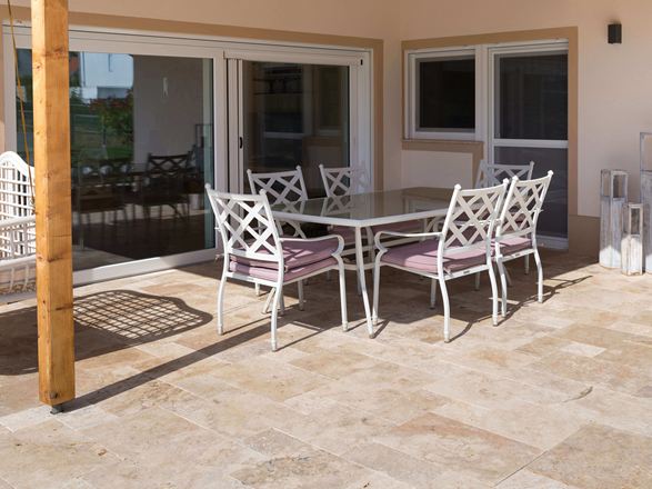 Terrazza in travertino con mobili bianchi
