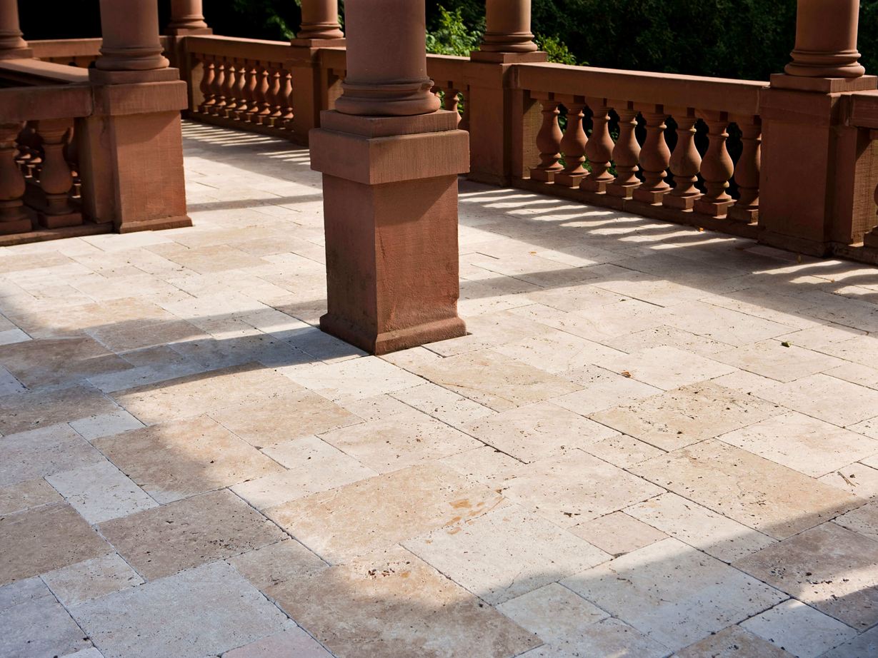 Un formato con tradizione: la fascia romana Terrazza del castello con colonne in pietra naturale e lastre in pietra naturale di travertino come pavimento