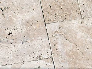 Primo piano di lastre di travertino in beige chiaro con pori tipici del travertino