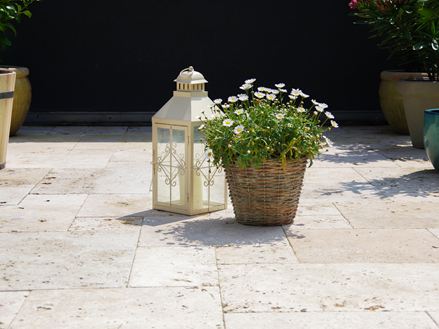 Lastre di travertino rustico con lanterna e fiori