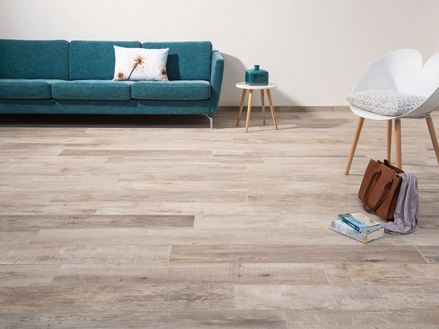 Soggiorno con Piastrelle effetto legno Indie Sky, sedia bianca e divano verde scuro