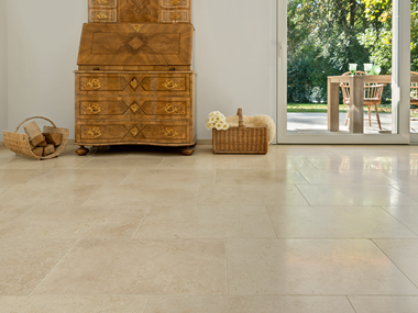 Antico mobile in legno su piastrelle di calcare chiaro Cleopatra Light, sullo sfondo vista della terrazza e del giardino