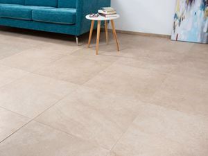 Piastrelle effetto calcare con divano turchese e tavolino bianco