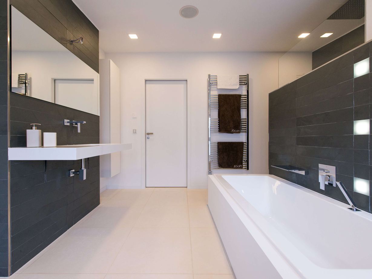 Bagno moderno con piastrelle in pietra calcarea chiara a pavimento e ardesia scura a parete