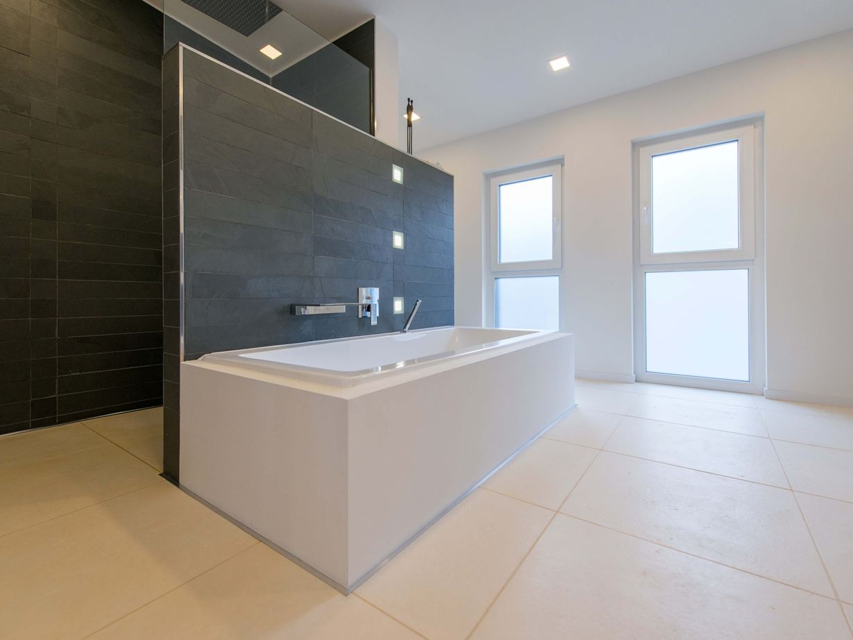 Vasca da bagno su piastrelle di calcare chiaro e ardesia come rivestimento delle pareti