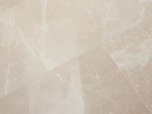 Piastrella in marmo Burdur Cream posata con superficie lucida e venature bianche nella zona di fondo beige