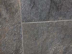 Piastrelle di quarzite posate in tonalità di verde scintillanti con fughe strette e chiare