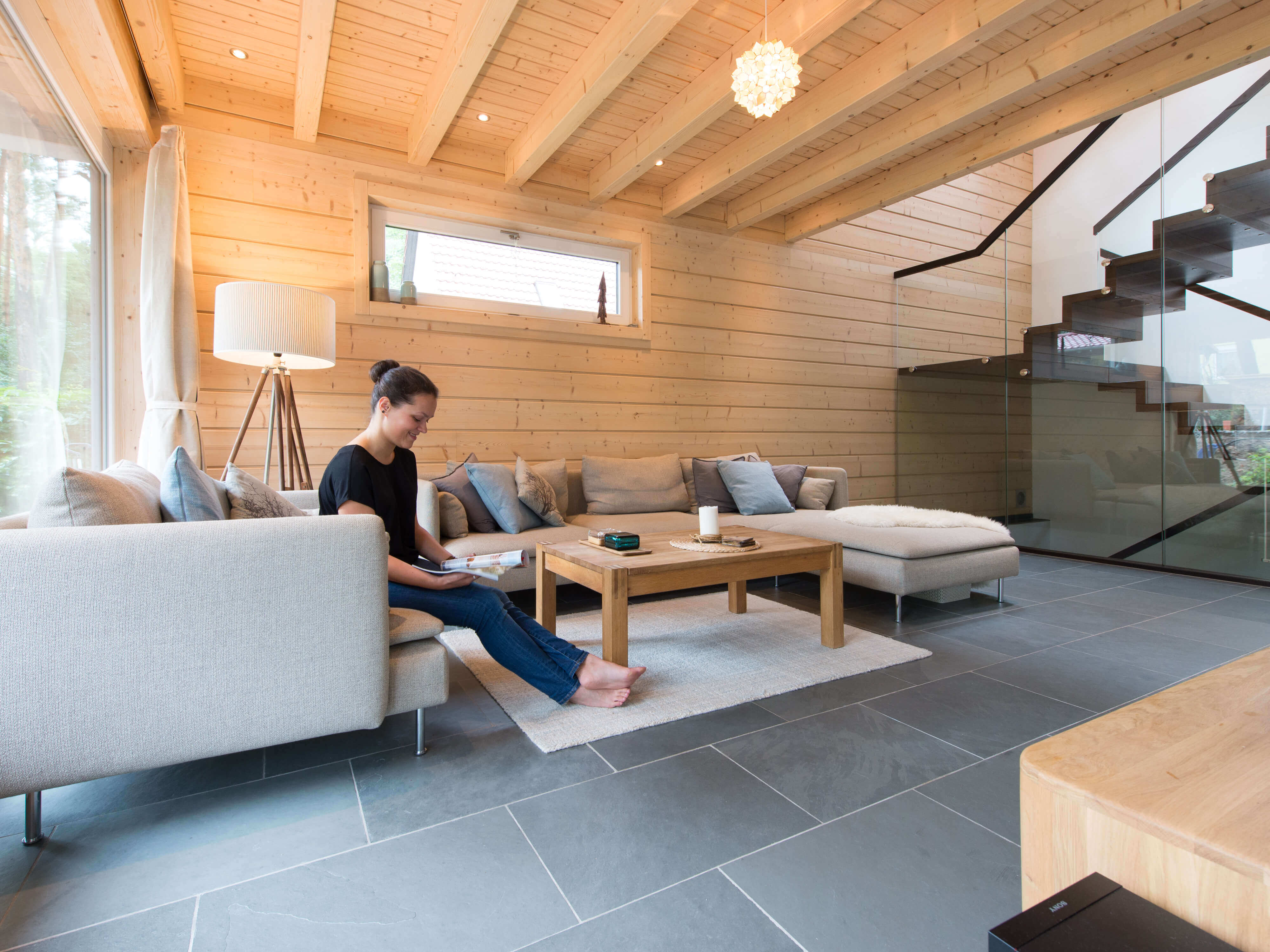 Donna in soggiorno con piastrelle in Grey Slate e parete in legno