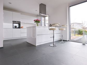 Cucina bianca con elementi in metallo su piastrelle di ardesia grigia con superficie a spacco