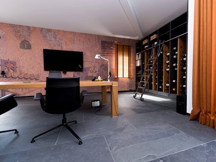 Ufficio con scaffale per vini e tavolo in legno, pavimento in piastrelle di ardesia Mustang