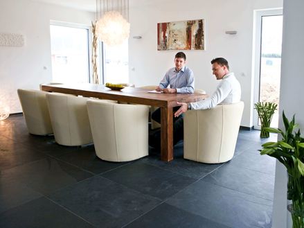 Tavolo da pranzo con poltrone bianche e due persone su piastrella di ardesia Mustang grigio scuro