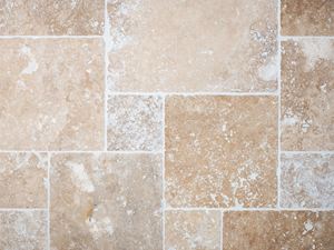 Vista a volo d'uccello di piastrelle di travertino posate e stuccate in beige e marrone