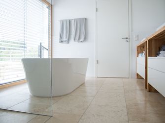 Bagno moderno con travertino Classic Light e vasca freestanding