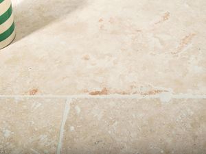 Di tanto in tanto si scoprono anche singole venature di colore rossastro - solo la pietra naturale è così unica. Ombra di un vaso di fiori su travertino Ivory Cream