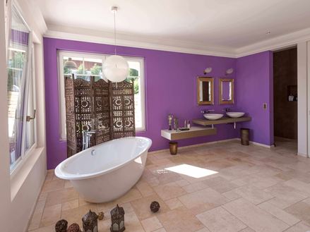 Bagno con Piastrelle Light in travertino, parete viola e vasca autoportante