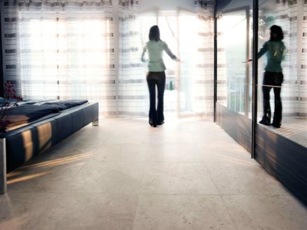 Piastrelle in travertino Medium Line con donna alla finestra