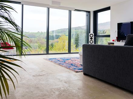 Soggiorno con piastrelle in travertino Medium Line e grande finestra frontale