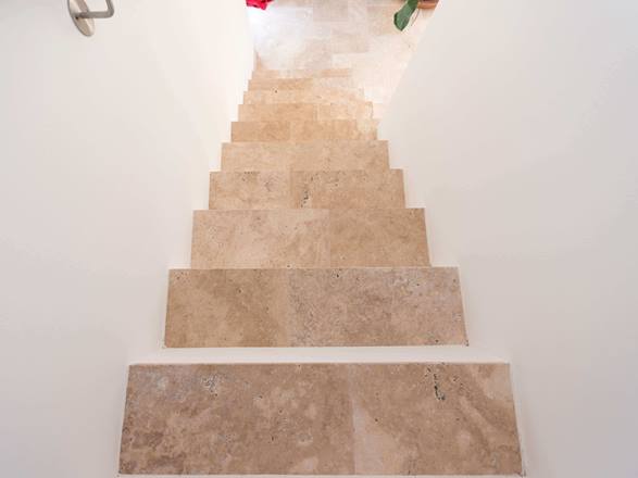 Scala con pareti bianche e travertino Medium come pedata