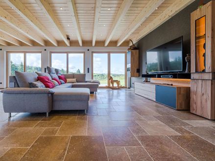 Soggiorno con divano grigio e piastrelle in travertino Noce SELECT marrone.