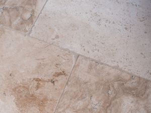 Primo piano della posa di una piastrella di travertino Rustic