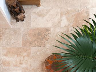 Vista a volo d'uccello di piastrelle di travertino posate Rustic con piante e accessori in legno