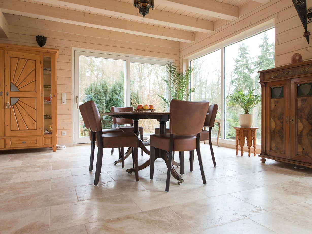 Zona pranzo con mobili in legno e pavimento in travertino rustico