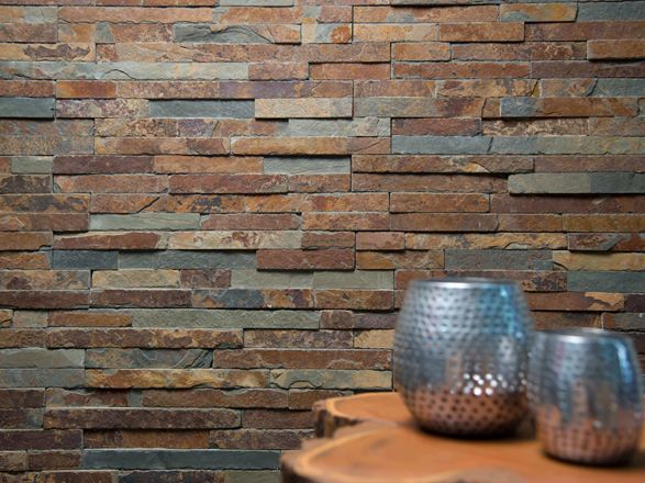 Due vasi su un tavolo di legno di fronte a una parete rivestita di ardesia naturale dalle tonalità brillanti