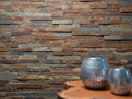 Due vasi su un tavolo di legno di fronte a una parete rivestita di ardesia naturale dalle tonalità brillanti