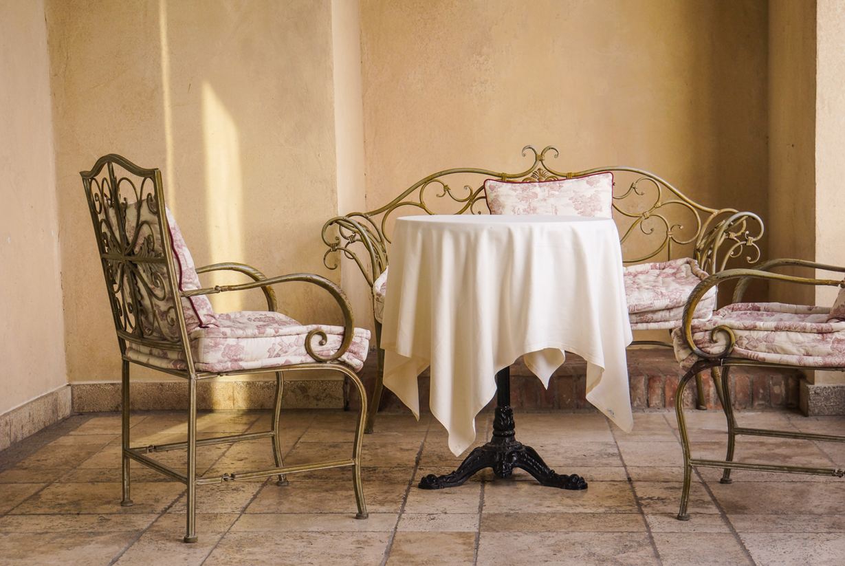 Eleganti sedute in stile francese con pavimento in pietra naturale di colore chiaro