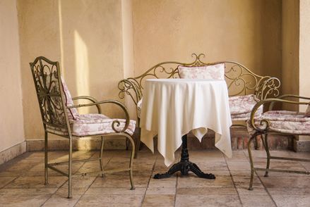 Eleganti sedute in stile francese con pavimento in pietra naturale di colore chiaro